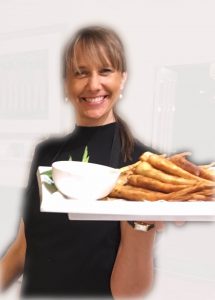 Gaelle Morival the business owner smiling and offering a platter of canapés